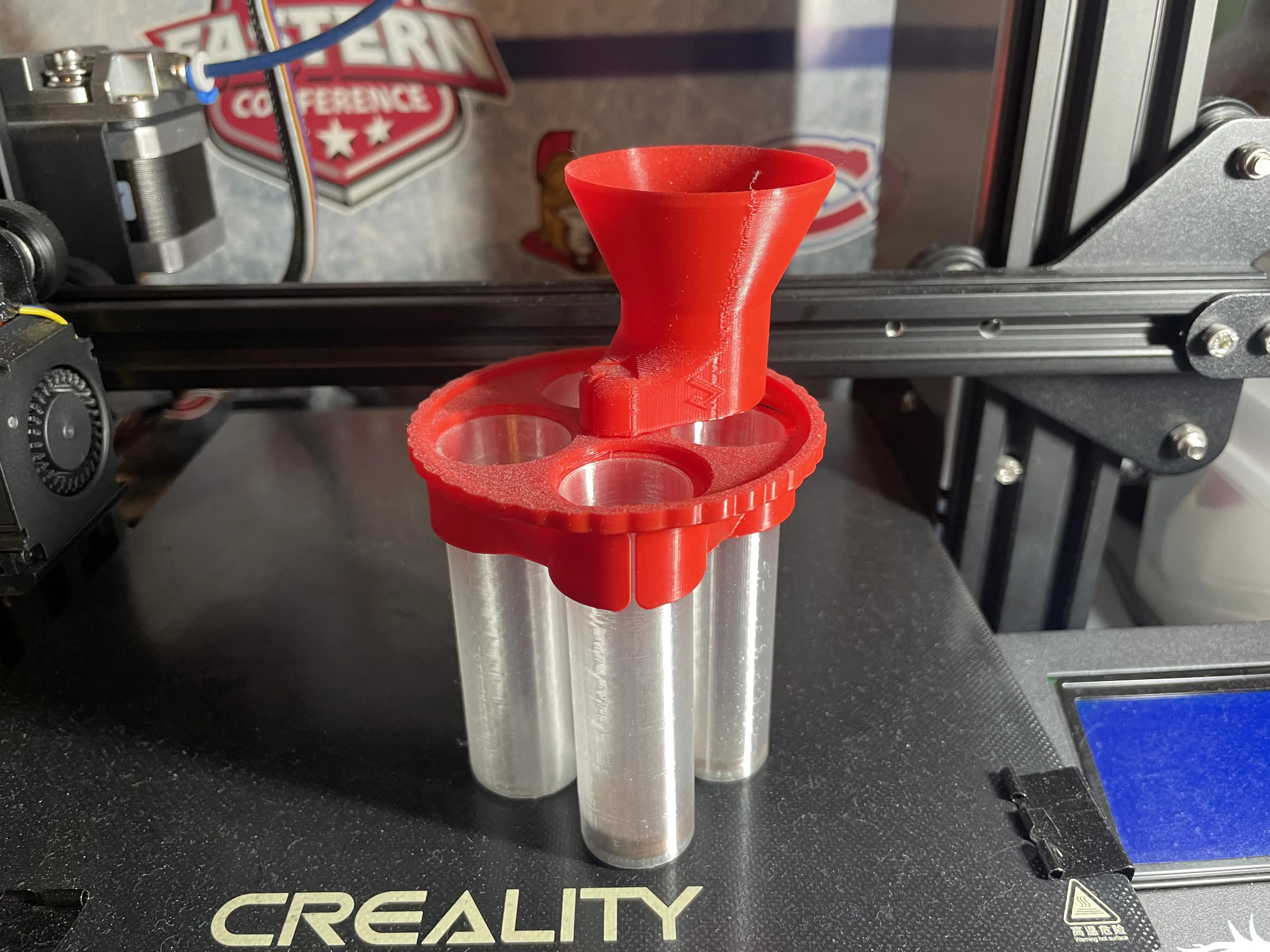 A clear and red, 3D printed coin bank with a mechanism to sort coins into clear individual tubes.